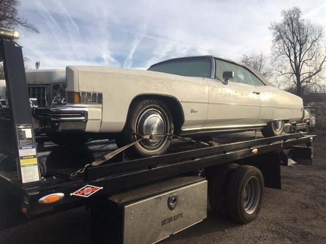 Classic Cadillac strapped onto a Double A Towing flatbed