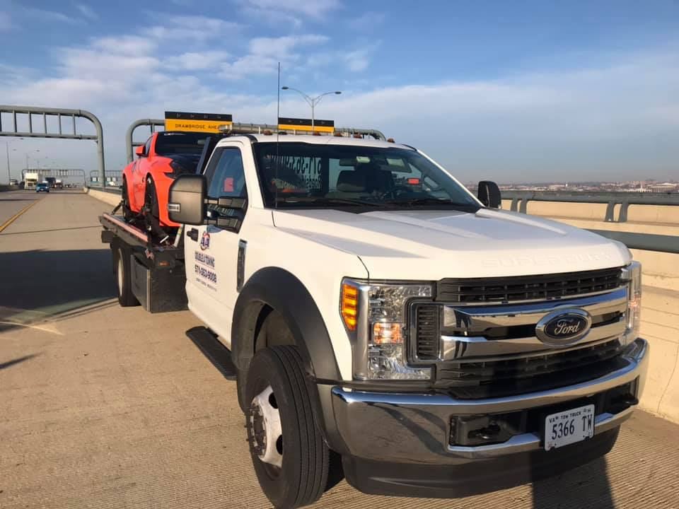 Double A Towing Ford flatbed carrying an orange sports car